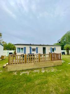 a house with a wooden deck in the yard at Bungalow Katalina in Bourbourg