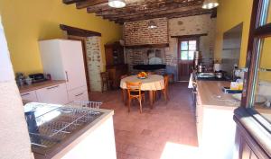 a kitchen and dining room with a table in it at Maison d'hôtes Le Rancher in Teloché +10 photos