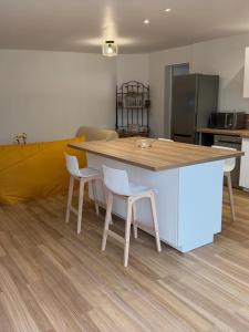 a kitchen with a table and two white chairs at Le Grimpeur in Achères-la-Forêt +2 photos