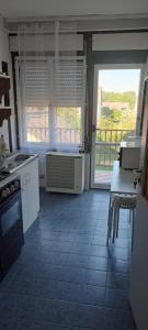 a kitchen with white appliances and a large window at Bluebird apartman in Zalakaros +20 photos