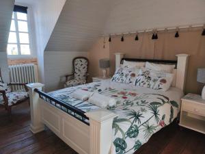 a bedroom with a large bed with a tropical bedspread at Ty Palms - Maison d'hôtes in Plomodiern