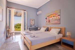 a bedroom with two beds and a large window at Villa Irini in Porto Heli +201 photos