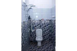 a bathroom with a toilet in a pile of rocks at minidu resort in Ambalantota +46 photos