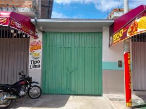 a green door on a building with a motorcycle parked in front at Casa Hospedaje en Tarapoto in Tarapoto +5 photos