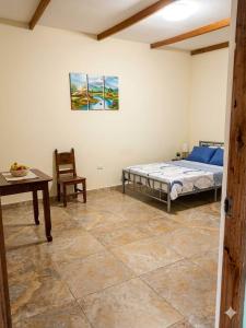 a bedroom with a bed and a table and a chair at Casa Hospedaje en Tarapoto in Tarapoto