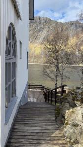 a building with a wooden walkway next to a lake at Salt&Stone in Gryllefjord
