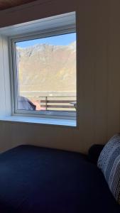 a window in a bedroom with a view of a mountain at Salt&Stone in Gryllefjord