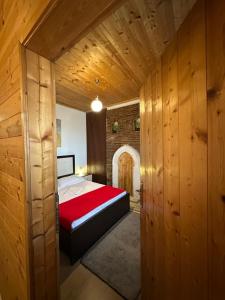 a bedroom with a bed and wooden walls at Rooms Merlika -Inside the Castle- in Krujë
