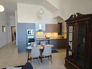 a kitchen with a table and chairs in it at Arzella Beachfront Guesthouse in Birżebbuġa