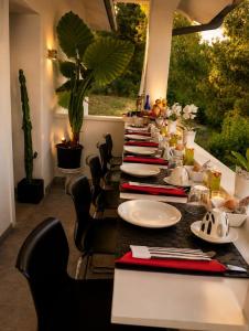 a long table with black chairs and plates on it at Gan Eden B&B in Monterenzio