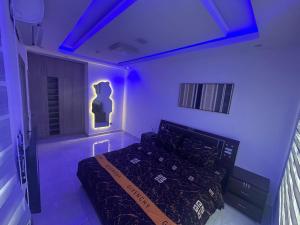 a bedroom with a bed with purple lights on it at Apartments 4B Block B in Lagos +1 photo