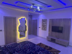 a room with a bed and a tv and a wall at Apartments 4B Block B in Lagos