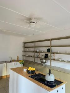 a kitchen with a stove with a pot on the counter at Garden Cottage - Self Catering in Amanzimtoti