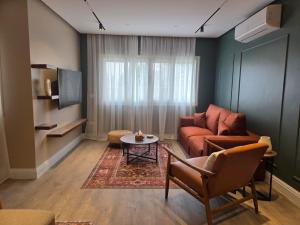 a living room with a couch and a table at Boho Chic 2BR Retreat Mountain View Executive in New cairo
