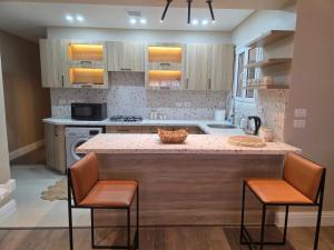a kitchen with a large island with two bar stools at Boho Chic 2BR Retreat Mountain View Executive in New cairo