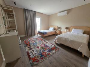 a bedroom with a bed and a rug on the floor at Boho Chic 2BR Retreat Mountain View Executive in New cairo +12 photos