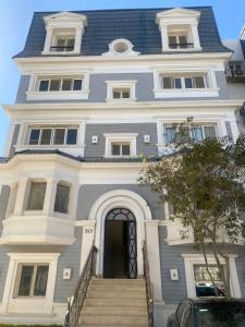 a large white house with stairs in front of it at Boho Chic 2BR Retreat Mountain View Executive in New cairo