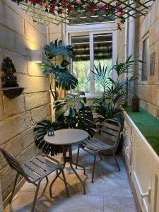 a patio with a table and chairs and plants at Melita Living in Sliema