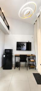 a dining room with a table and a tv on the wall at Mini Casa 02 - Próx Aeroporto e Centro Hospitalar in Teresina