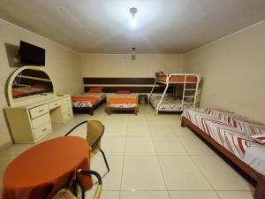 a room with two bunk beds and a table and chairs at Hospedaje Valencia in Ica