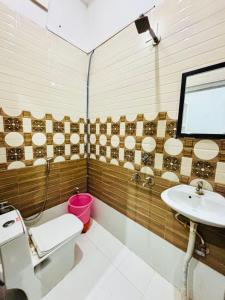 a bathroom with a toilet and a sink at Radha Krishna Hotel in Karauli