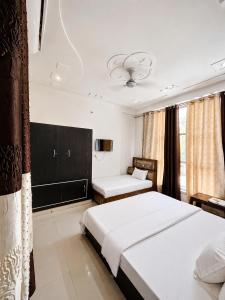 a bedroom with two beds and a tv in it at Radha Krishna Hotel in Karauli