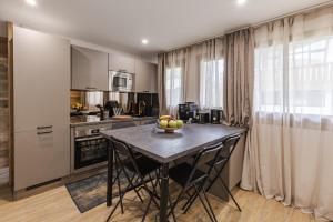 a kitchen with a table with a bowl of fruit on it at Les Caribous - Lac 1 min, Espace Diamant, Megeve in Praz-sur-Arly +32 photos