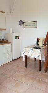 a kitchen with a table and a white refrigerator at Ra's Seacastle in Tsoutsouros