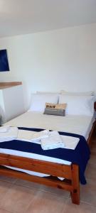 a bed in a room with white sheets and pillows at Ra's Seacastle in Tsoutsouros