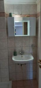 a bathroom with a sink and a mirror at Ra's Seacastle in Tsoutsouros +20 photos