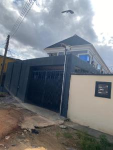 a house with a blue gate in front of it at Asika Luxe Living in Ayobo +10 photos