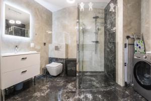 a bathroom with a shower and a toilet and a sink at Apartament Baltic Prestige in Gąski +22 photos