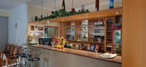 a bar in a restaurant with a counter and chairs at PENZION EUROPA Diakovce in Diakovce