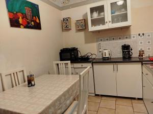 a kitchen with white cabinets and a table and a counter top at Vanilla House Paleokastritsa in Paleokastritsa