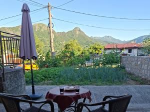 a table with two chairs and an umbrella on a patio at Apartman Pavle Virpazar in Virpazar