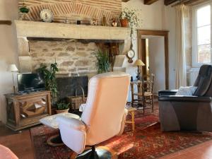 a living room with a chair and a fireplace at Gîte Le Tremblay in Thianges