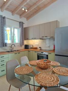 a kitchen with a glass table with baskets on it at Villa Eleni Apartment no2 in Agios Gordios +9 photos