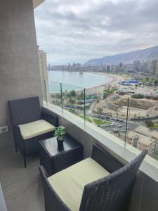 a balcony with chairs and a view of the water at PENINSULA DE CAVANCHA, Vista ESPECTACULAR in Iquique