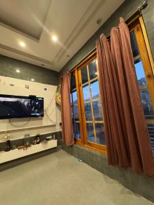 a living room with a television and a window at kingsgate in Nerul