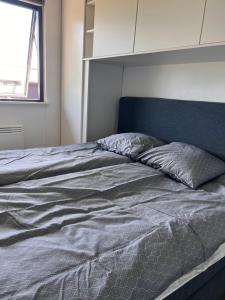 an unmade bed in a bedroom with a window at House with a lovely location in Børkop