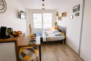 a small room with a bed and a desk with a desk at Chez Coco - Studio à 200m de la Gare ! in Besançon