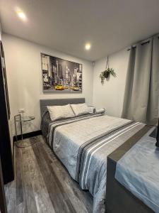 a bedroom with a bed and a picture on the wall at Studio Moderne Chic Gatineau Ottawa in Gatineau