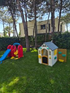 a yard with some play equipment in the grass at Peonia Villa ValaMar in Draç