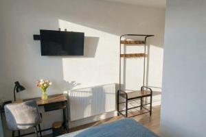 a room with a desk and a chair and a television at Apartamenty Raszyn in Raszyn