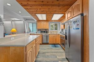 a kitchen with wooden cabinets and stainless steel appliances at Agate Bay Chalet in Carnelian Bay +40 photos