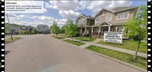 a house with a for sale sign in the street at Parson Creek Cozy suite in Fort McMurray