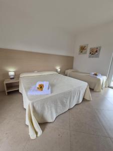 a room with two beds with a teddy bear on a towel at Albergo Athena Mare in Sibari