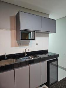 a kitchen with a sink and a microwave at D Castro Executive in Montes Claros