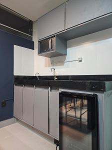 a kitchen with white cabinets and a stove top oven at D Castro Executive in Montes Claros +8 photos