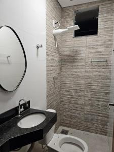 a bathroom with a sink and a toilet and a mirror at D Castro Executive in Montes Claros